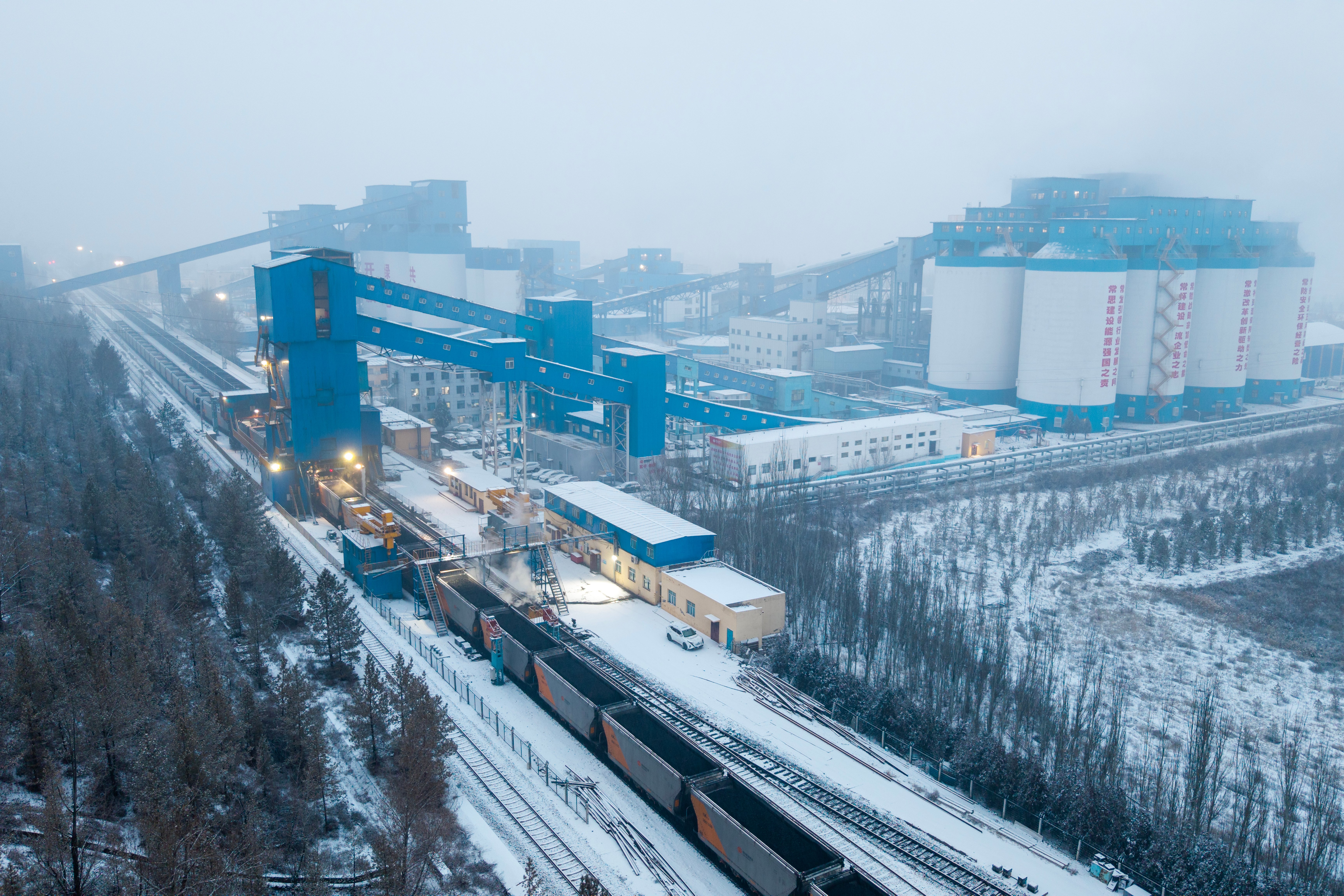 為積極應對寒潮挑戰,神東煤炭多維度筑牢嚴寒保供防線,各礦井與洗選中心協同作戰,全力確保煤炭供應。圖為神東煤炭補連塔煤礦裝車外運航拍大景。--劉長江攝