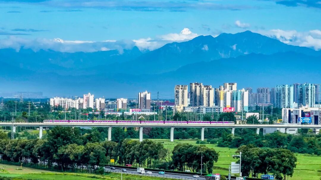 列車穿行于雪山下的公園城市1.jpg